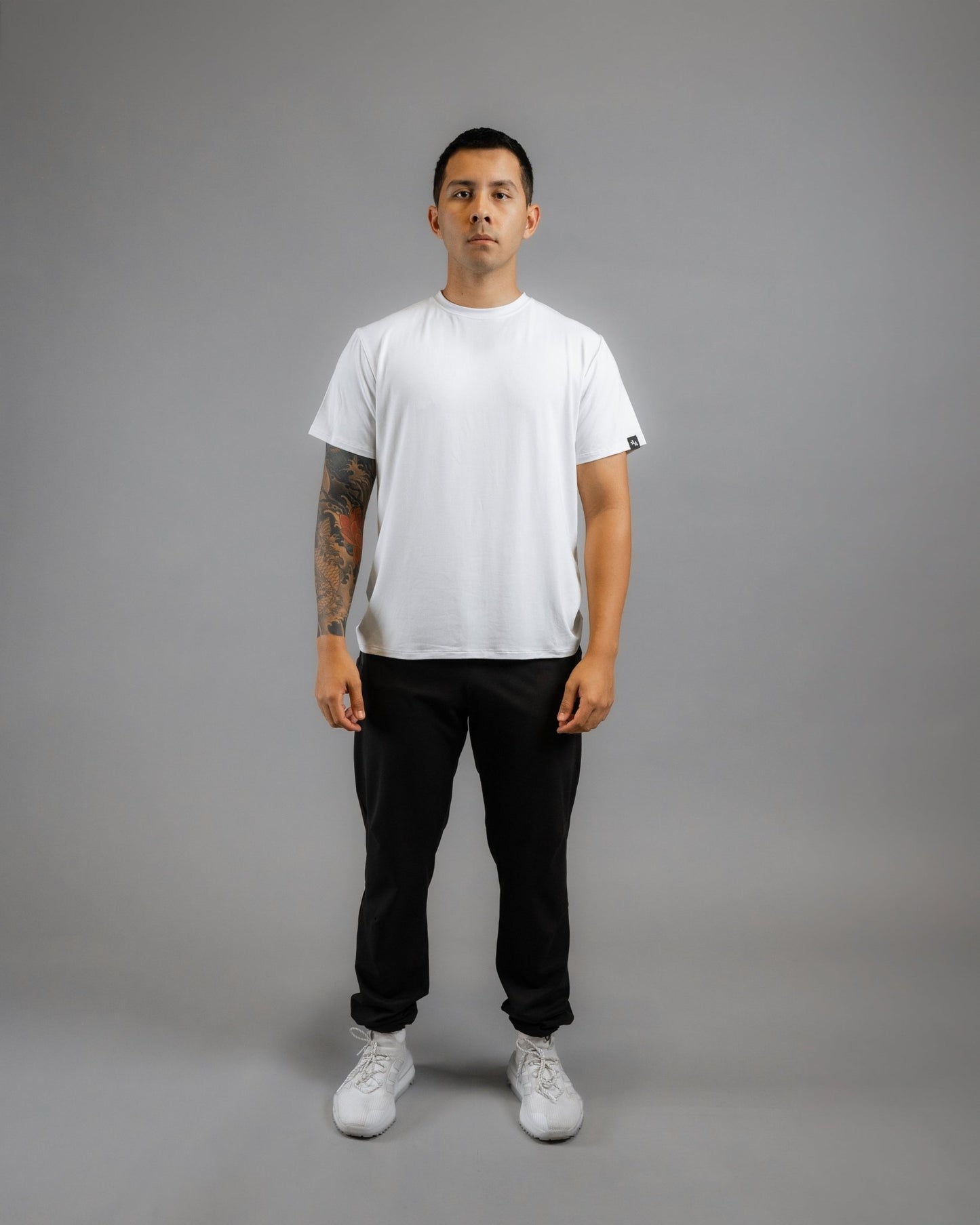 Male facing forward wearing the ALL IN ALL SUPERNATURAL II JOGGER in black and Supernatural Bamboo shirt in off white