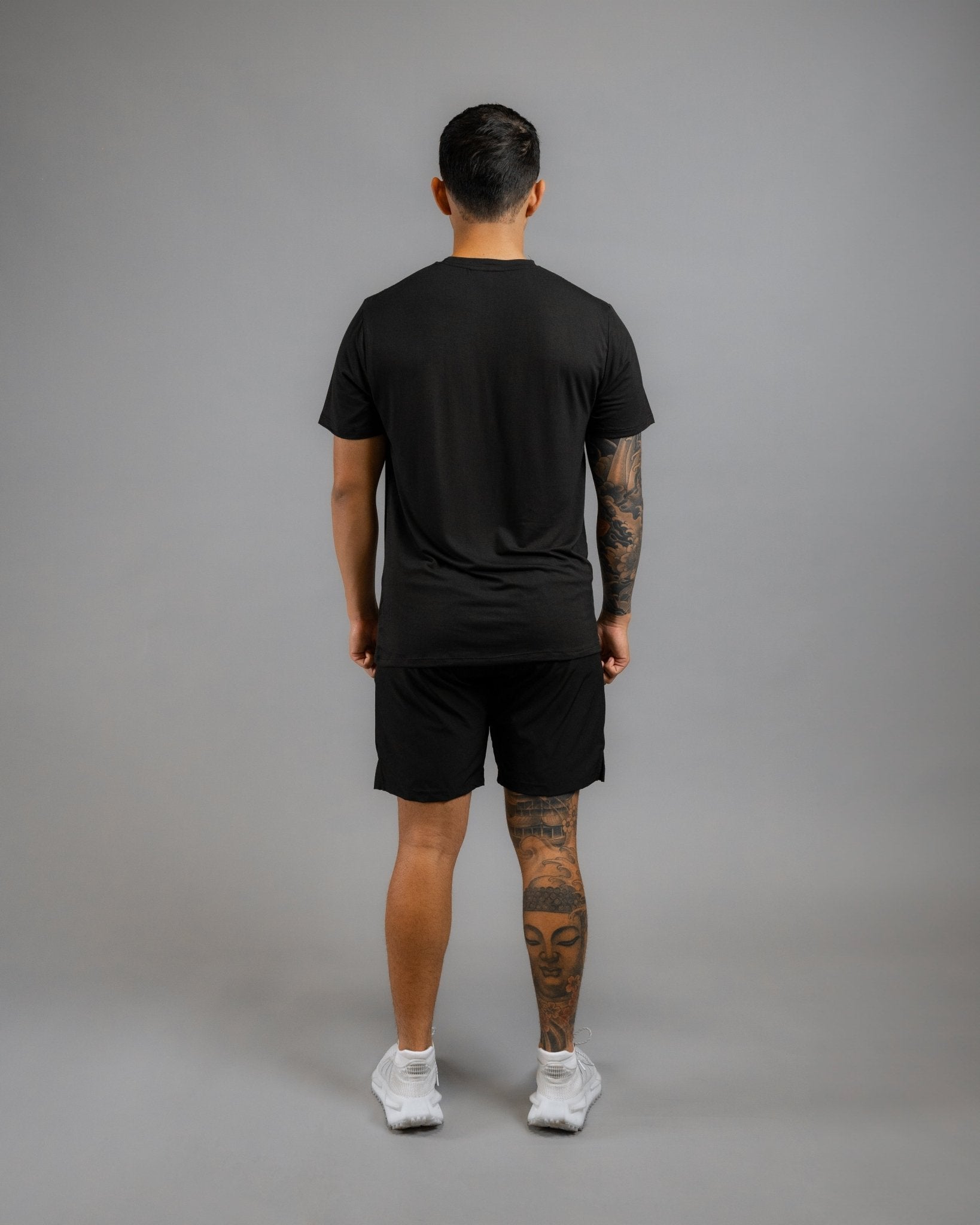 backside of model wearing ALL IN ALL black supernatural tee and black supernatural short