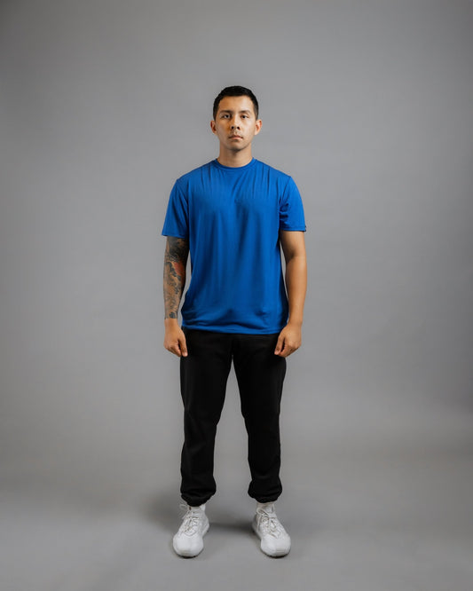 model facing forward wearing ALL IN ALL blue supernatural bamboo tee with black supernatural II jogger