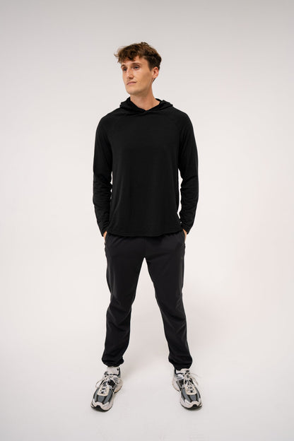 Male model wearing an ALL IN ALL black hoodie and ALL IN ALL black joggers against a white background