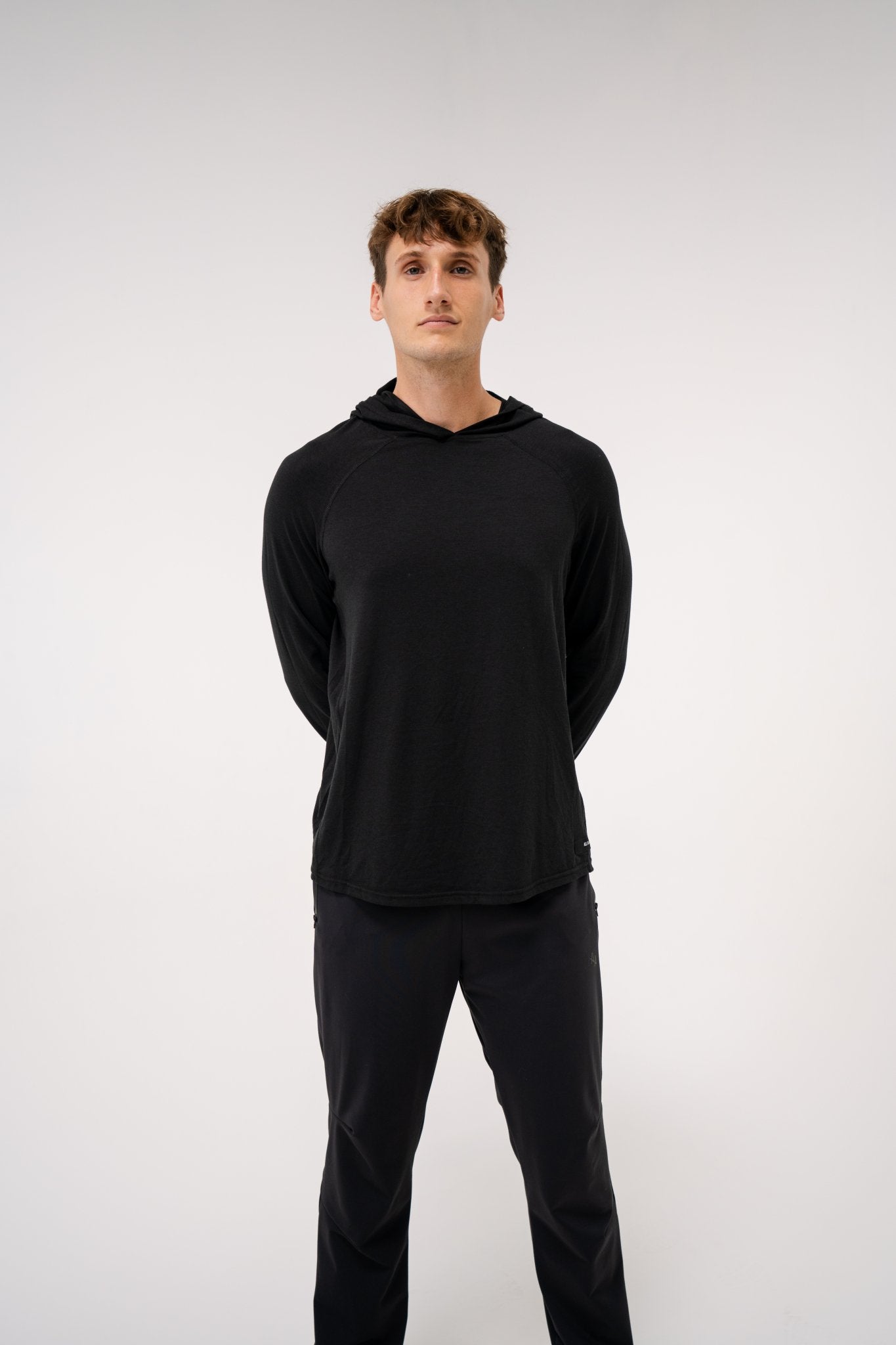 Male model wearing an ALL IN ALL black hoodie and ALL IN ALL black joggers on a white background