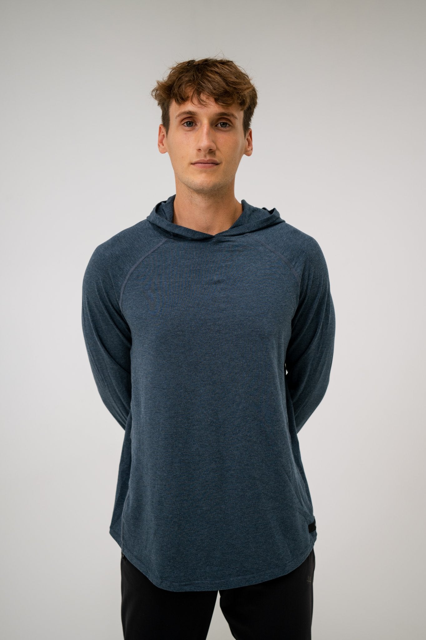 Male model wearing an ALL IN ALL heather blue hoodie against a plain background
