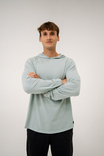Male model wearing an ALL IN ALL mojito hoodie with arms crossed against a plain background