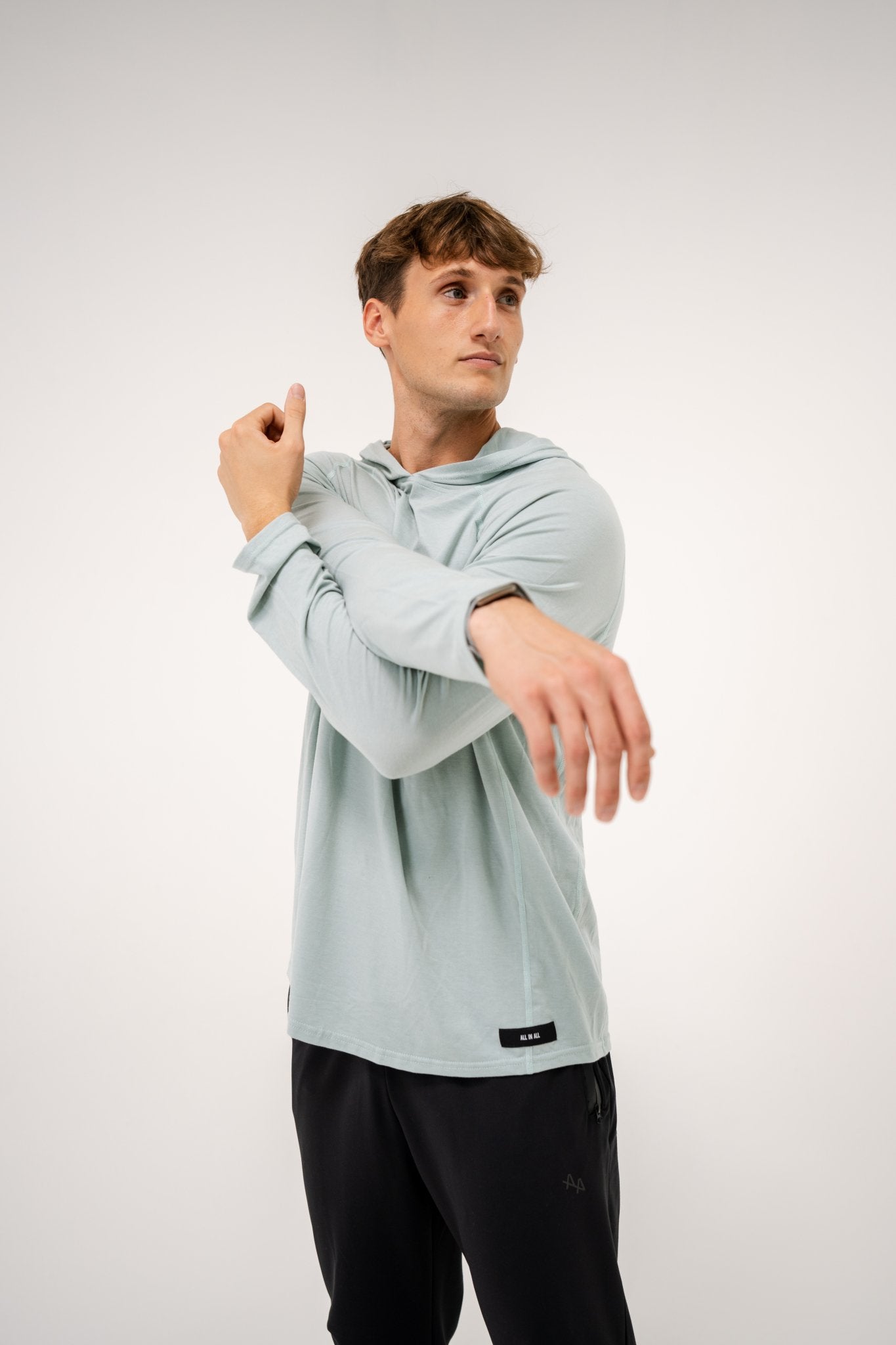 Male model wearing an ALL IN ALL mojito hoodie and ALL IN ALL black joggers on a white background